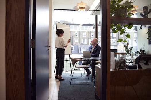 Empresas Colleagues engage in a strategic business meeting in a contemporary London office with city views.